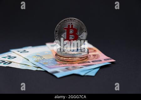 Bitcoins avec symbole rouge sur les billets de banque de 20 et 10 euros. Bitcoins sur des billets de dix et vingt euros sur fond sombre. Banque D'Images