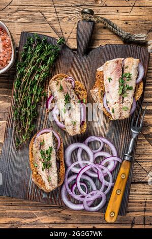 Toasts avec sardine, fromage à la crème et oignon. Arrière-plan en bois. Vue de dessus Banque D'Images