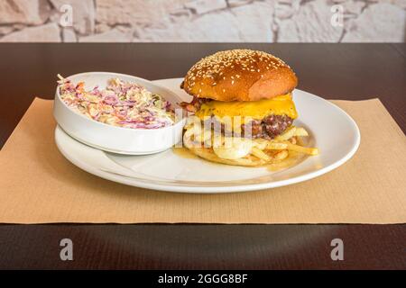 Hamburger de bœuf avec deux sortes de fromage fondu, frites à l'intérieur du hamburger et loi froide américaine Banque D'Images