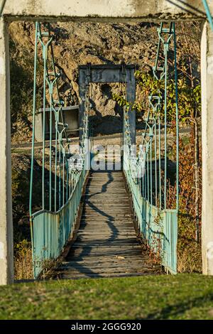 Ancien pont suspendu en métal bleu et en bois sur un affluent de l'Arda près de Kardzhali, dans le sud de la Bulgarie Banque D'Images