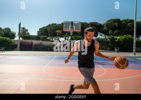 un joueur de basket-ball s'entraîne sur le terrain de basket-ball en cours d'entraînement. Été Banque D'Images