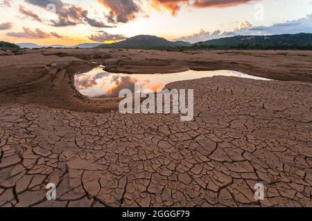 Terre fissurée près de l'eau de séchage au crépuscule à Sam Pan Bok dans le Mékong. Province d'Ubonratchathani, Thaïlande Banque D'Images