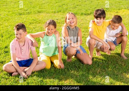 Cinq enfants assis sur l'herbe Banque D'Images