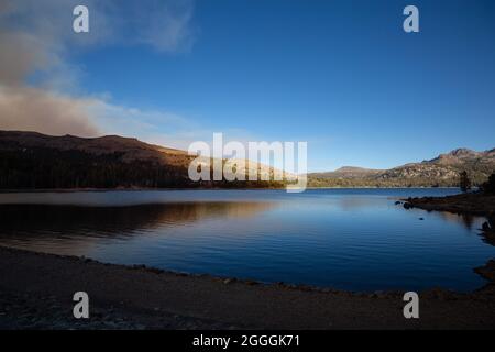 El Dorado County, États-Unis. 31/08/2021, la fumée épaisse du feu Caldor jette de l'ombre sur une colline le long du lac Caples dans le comté d'El Dorado, en Californie. Banque D'Images