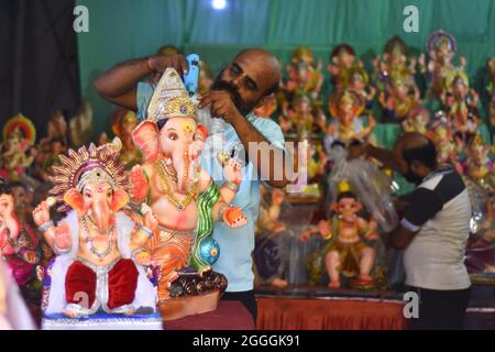 Jabalpur : un artiste qui donne une touche finale à lord Ganesha lors d'un atelier en prévision du festival Ganesh Chaturthi, à Jabalpur, le dimanche 29 août 2021. PH Banque D'Images