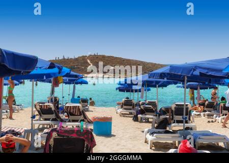 Blue Beach parasols et chaises longues sur la plage de sable d'Ayia Napa, Chypre Banque D'Images