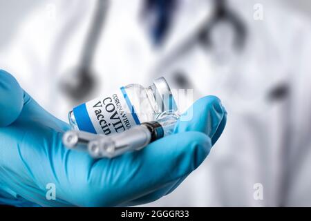 Un médecin distribue un flacon en verre étiqueté Covid-19. Banque D'Images