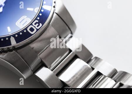 Montre poignet Mans fragment boîtier en acier inoxydable, avec boîtier bleu et cadre en céramique rotatif, fabriqué en Suisse. Gros plan avec mise au point douce sélective Banque D'Images