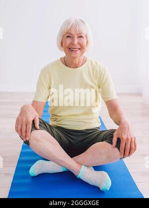 femme senior faisant du yoga à l'intérieur. Anti âge, sport, yoga concept Banque D'Images