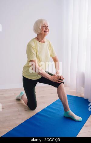 femme senior faisant du yoga à l'intérieur. Anti âge, sport, yoga concept Banque D'Images