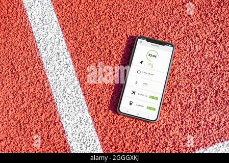 Téléphone posé sur le terrain de sport avec concept d'application de course à pied Banque D'Images