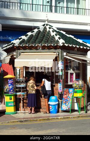 Les femmes magasinent dans un kiosque à journaux et à glaces, Nerja, Espagne. Banque D'Images