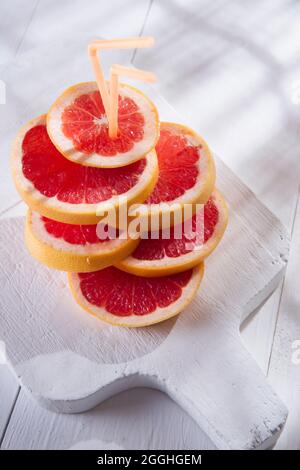 Apéritif avec tranches de pamplemousse rouge sur la bordure blanche Banque D'Images