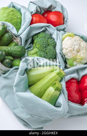 Légumes frais dans les sacs d'épicerie de vente de textile sur une table blanche, concept zéro déchet. Plan à plat. Espace pour le texte. Vue de dessus. Photo de haute qualité Banque D'Images