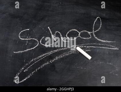 Le mot école écrit avec craie sur un tableau noir Banque D'Images