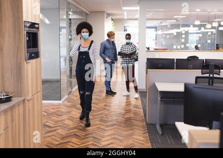 Divers collègues masculins et féminins portant des masques, travaillant ensemble Banque D'Images