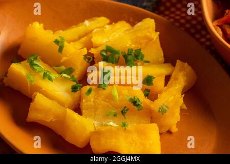 portion de manioc cuit arrosée de ciboulette. Banque D'Images