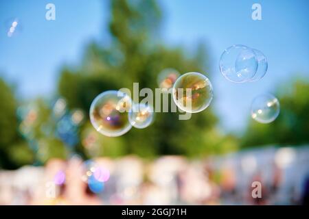 De belles bulles de savon au parc par temps ensoleillé. Beaucoup de bulles dans l'air. Arrière-plan flou. Photo de concept d'enfance. Image de grande taille. Banque D'Images