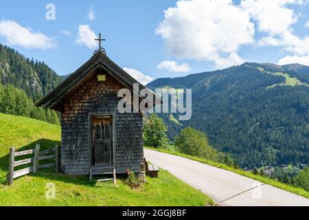 Petite chapelle chrétienne en bois à côté d'une rue dans les Alpes tyroliennes en Autriche Banque D'Images