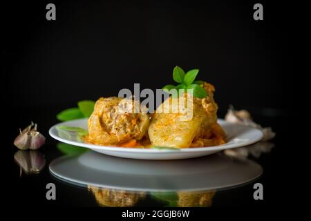 sauce aux poivrons farcis avec de la viande et du riz dans une assiette sur fond noir Banque D'Images