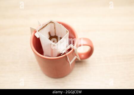 Le café coule dans la tasse. Préparation de café de spécialité dans des sacs-filtres en papier. Banque D'Images
