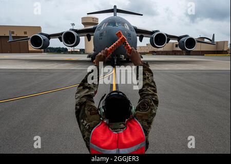 Le principal Airman Elijah Turner, chef d'équipage du 911e Escadron de maintenance d'aéronefs, signale à l'équipage d'un C-17 Globemaster III de s'arrêter à la place de stationnement désignée sur la ligne de vol à la station de réserve aérienne de l'aéroport international de Pittsburgh, en Pennsylvanie, le 31 août 2021. Le stationnement de l'avion a marqué la fin des efforts d'évacuation en Afghanistan pour les membres de la 911e Escadre du transport aérien. (É.-U. Photo de la Force aérienne par Joshua J. Seybert) Banque D'Images