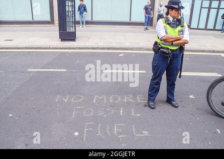 Londres, Royaume-Uni. 1er septembre 2021. Un policier se trouve à côté d'un message écrit à la craie à l'extérieur du ministère des Affaires, de l'énergie et de la Stratégie industrielle. Extinction les manifestants de la rébellion ont organisé une manifestation « Greenwash » à Westminster, dans le cadre de leur campagne de deux semaines pour la rébellion impossible, qui a appelé le gouvernement britannique à agir de manière significative sur la crise climatique et écologique. (Crédit : Vuk Valcic / Alamy Live News) Banque D'Images