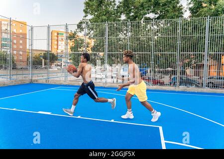 Des amis africains forts et en bonne santé jouant au basket-ball et s'amusant. Banque D'Images