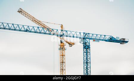 Haabneeme, Harjumaa, Estonie - 02.04.2021: Grues à tour bleues et jaunes de type marmerhead sur fond de ciel nuageux Banque D'Images