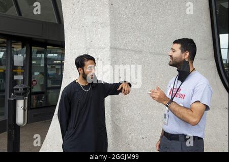 Chantilly, Virginie, États-Unis. 1er septembre 2021.Mohammad Jelani, à gauche, un hélicoptère mécanicien de la base aérienne de Bagram qui a été évacué d'Afghanistan, partage une cigarette avec une escorte après son arrivée à l'aéroport international de Washington Dulles, à Chantilly, va, Etats-Unis, à 26 miles à l'ouest du centre-ville de Washington DC, le mercredi 1er septembre 2021. Photo de Rod Lamkey / CNP/ABACAPRESS.COM crédit: Abaca Press/Alay Live News Banque D'Images