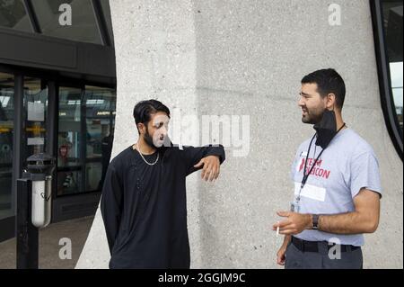 Chantilly, Virginie, États-Unis. 1er septembre 2021.Mohammad Jelani, à gauche, un hélicoptère mécanicien de la base aérienne de Bagram qui a été évacué d'Afghanistan, partage une cigarette avec une escorte après son arrivée à l'aéroport international de Washington Dulles, à Chantilly, va, Etats-Unis, à 26 miles à l'ouest du centre-ville de Washington DC, le mercredi 1er septembre 2021. Photo de Rod Lamkey / CNP/ABACAPRESS.COM crédit: Abaca Press/Alay Live News Banque D'Images