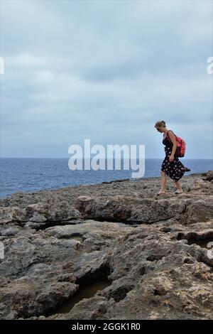 Jeune femme sur la côte rocheuse, plage rocheuse, rochers à Punta de n'Amer, Cala Millor, Majorque, Iles Baléares, Espagne Banque D'Images