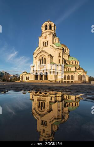 Belle vue et réflexion dans une flaque de la cathédrale Saint Alexandre Nevsky à Sofia, la capitale de la Bulgarie sur fond bleu ciel Banque D'Images