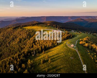 Ambiance au coucher du soleil au sommet de Kandel dans la Forêt Noire centrale. Photo de drone du sommet de Kandel avec le sommet de la pyramide et les randonneurs. Le Kandel est à 1241.3 m au-dessus du niveau de la mer. NHN le point le plus élevé de la forêt noire du Moyen-Orient et de la montagne locale de la ville de Waldkirch, district d'Emmendingen, Forêt Noire, Bade-Wurtemberg Banque D'Images