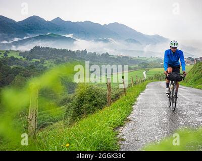 Excursion en vélo avec bagages, bikepacking sur une route côtière solitaire dans les Asturies, dans le nord de l'Espagne Banque D'Images