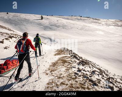 Deux skieurs lors d'une visite de ski avec des traîneaux de pulka à travers la réserve naturelle de la Réserve naturelle des hauts plateaux du Vercors, descente au Col du Rousset Banque D'Images