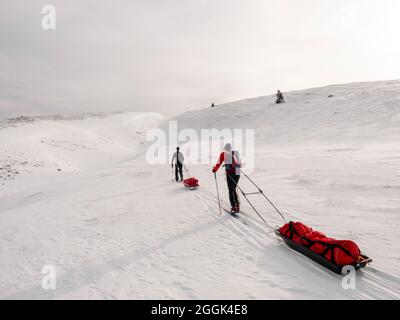 Deux skieurs lors d'une visite de ski avec des traîneaux de pulka à travers la réserve naturelle de la Réserve naturelle des hauts plateaux du Vercors, ascension au Col du Rousset Banque D'Images