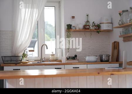 Superbe intérieur de cuisine de luxe dans la couleur blanche avec une île de cuisine en bois. Photo de haute qualité Banque D'Images