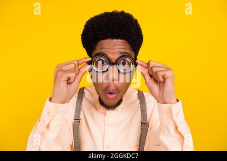 Photo portrait homme en chemise portant des lunettes de contrôle de la vue stupéfait isolé couleur jaune vif fond Banque D'Images