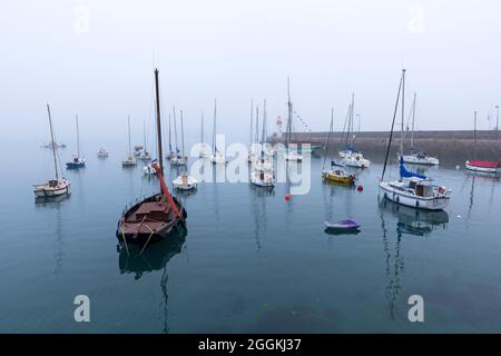 Ambiance brumeuse dans le port d'Erquy, en arrière-plan le petit phare sur la jetée, France, Bretagne, Département Côtes d'Armor, Côte de Penthièvre Banque D'Images