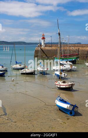 Marée basse dans le port d'Erquy, les bateaux se trouvent dans le sable, en arrière-plan le petit phare sur la jetée, France, Bretagne, Côtes d'Armor, Côte de Penthièvre Banque D'Images