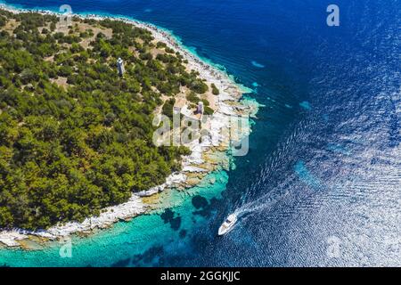 Phare du village de Fiskardo. Le yacht en mer bleue arrive dans le port de l'île de Kefalonia, Grèce Banque D'Images