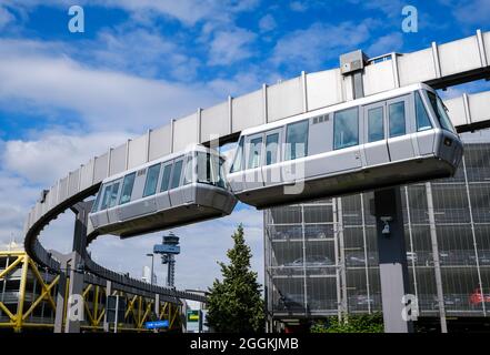 Düsseldorf, Rhénanie-du-Nord-Westphalie, Allemagne - le SkyTrain, le téléphérique de l'aéroport de Düsseldorf, amène les passagers de la gare longue distance et des parkings au terminal et à l'arrière, avec la tour de l'aéroport à l'arrière. Banque D'Images