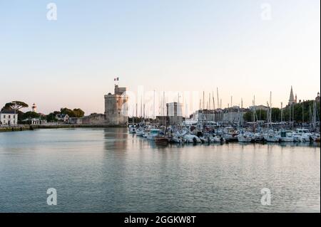 La Rochelle, France ; 10 août 2021 : entrée de l'ancien port médiéval de la Rochelle au crépuscule. Flanquée de la Tour de Saint Nicolas sur la gauche de Banque D'Images