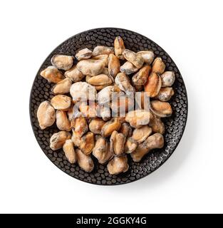 Viande de moule cuite congelée sur une plaque en céramique texturée noire isolée sur fond blanc. Moules pelées comme ingrédient de savoureuses recettes de fruits de mer. Banque D'Images