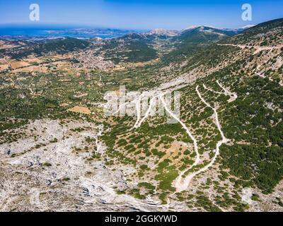 Vue aérienne d'une route locale en serpentin à travers le terrain montagneux de l'île de Zakynthos. Banque D'Images