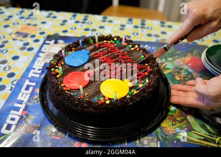 Homme coupant gâteau d'anniversaire au chocolat, gros plan - USA Banque D'Images