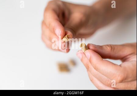Gros plan avec une capsule d'herbe sur fond blanc. Concept de microdosage. Thérapie de psychédéliques. Dépression, traitement de l'anxiété Banque D'Images