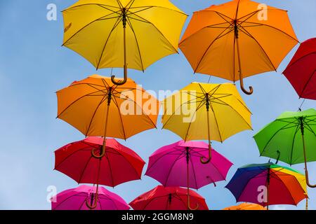 Parasols colorés contre un ciel bleu à Masevaux en Alsace, France Banque D'Images