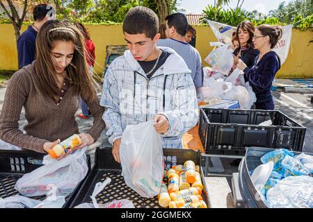 Miami Florida,Thanksgiving turquie libre de nourriture bénévoles bénévoles travaillant en aidant, hispanique fille garçon adolescent adolescents adolescents étudiants préparer Banque D'Images